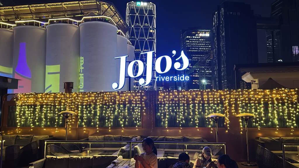 JoJo's Riverside Rooftop at night with fairy lights and skyline backdrop