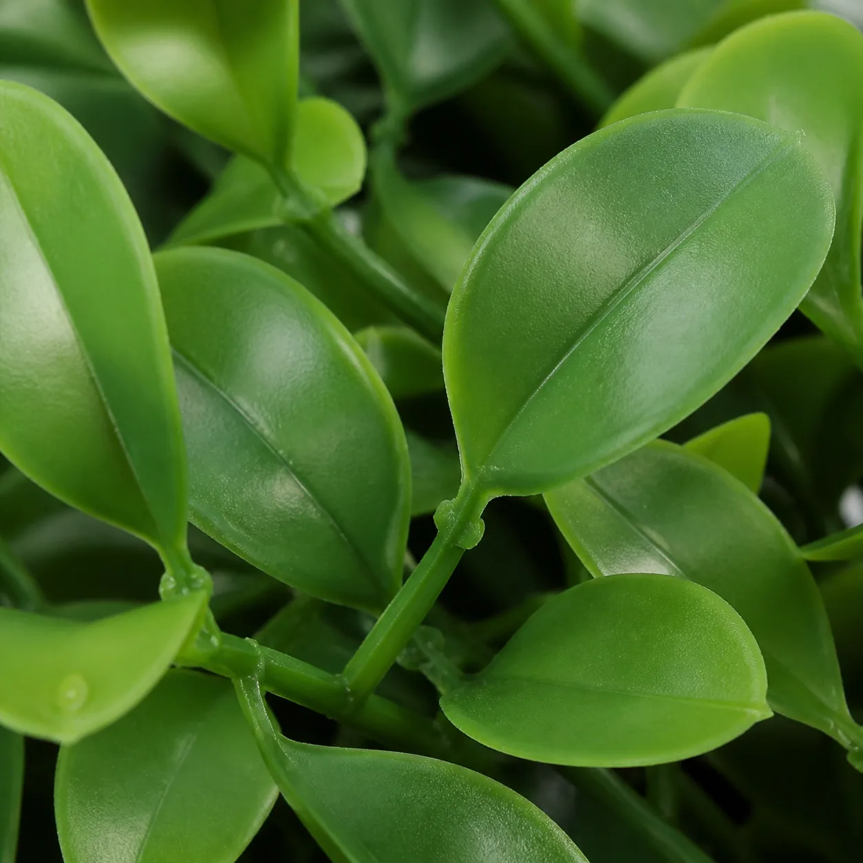 Close-up of UV-stabilized HDPE artificial plant leaves — smooth, vibrant green surface with no fading or surface cracking, demonstrating superior UV resistance